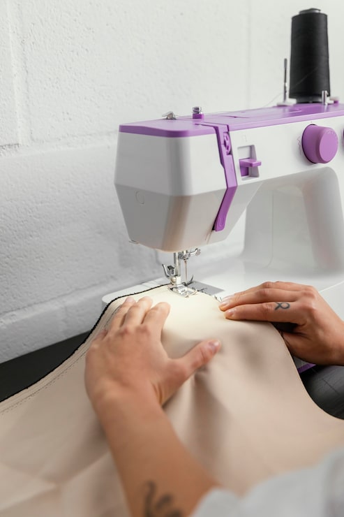 Foto gratuito mujer que trabaja en su taller de diseño de moda