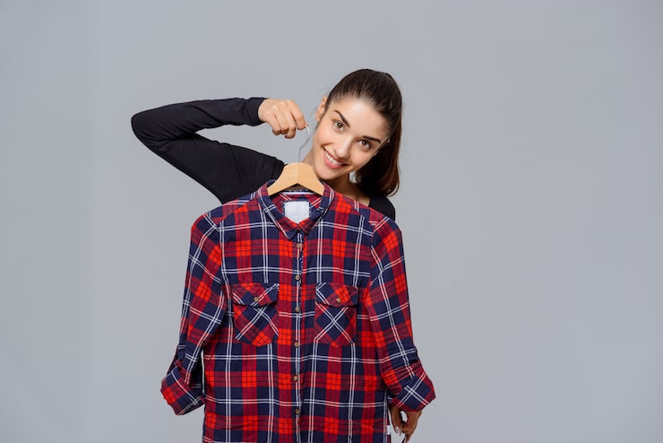 Foto gratuito mujer sosteniendo camisas, eligiendo qué ropa usar