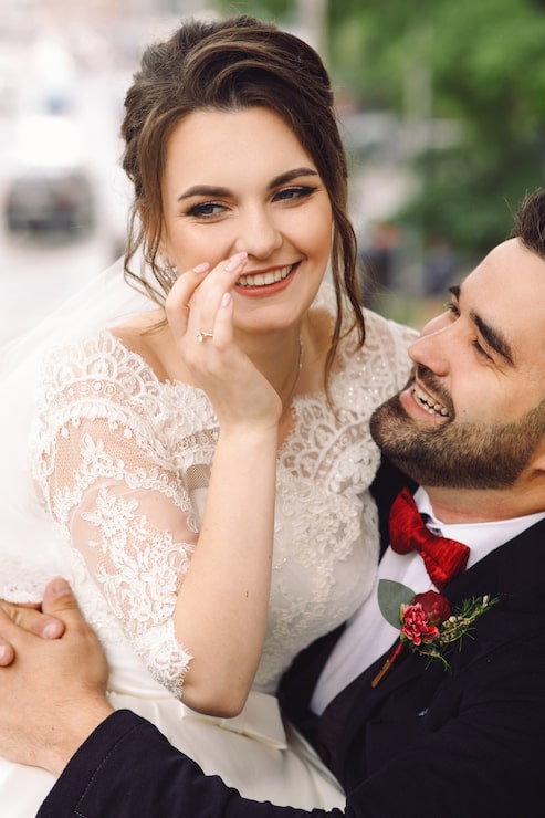Foto gratuito el novio en silla de ruedas detiene a la novia de rodillas sentado afuera en el parque