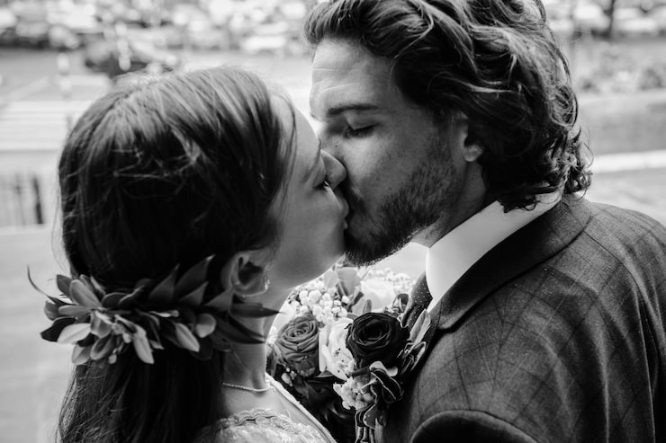 Foto gratuito novios besándose fuera de la iglesia