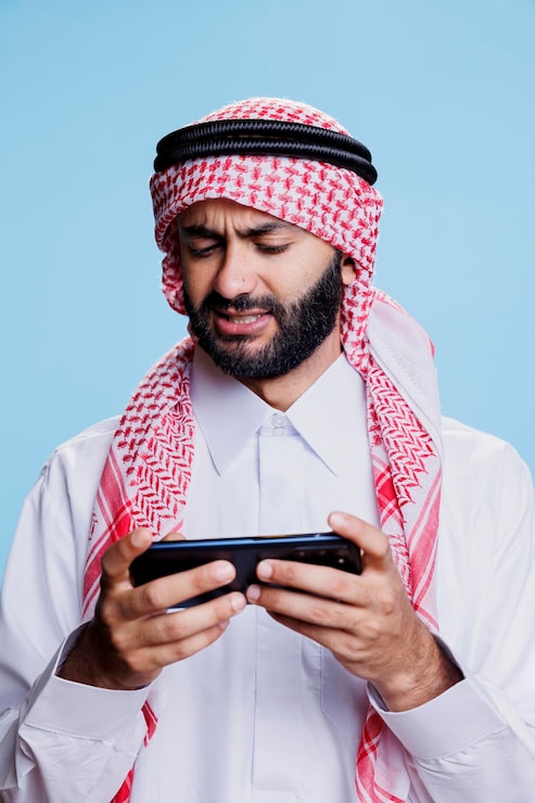 Photo Gratis orang arab bermain videogame di smartphone