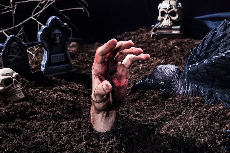 Foto gratuito pájaro espeluznante que intenta morder la mano de zombie en el cementerio de halloween