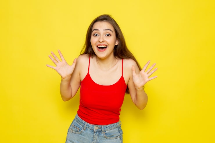 Photo Gratis pandangan depan seorang wanita muda cantik berbaju merah dan celana jeans biru tersenyum