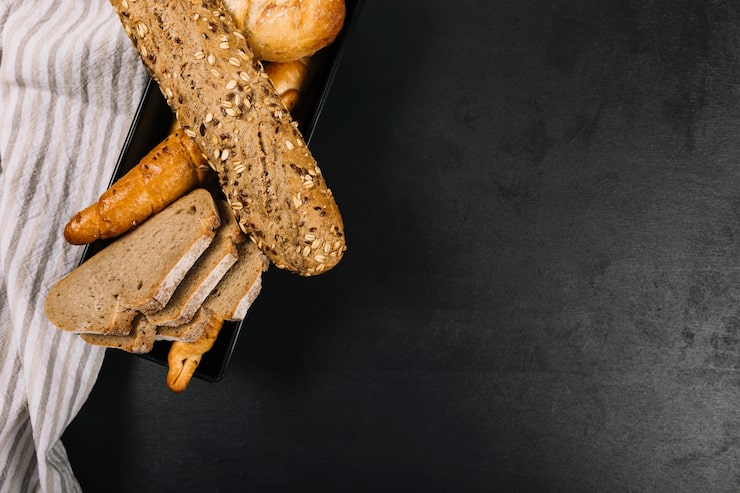 Foto gratuito panes integrales al horno con servilleta sobre encimera de cocina negra
