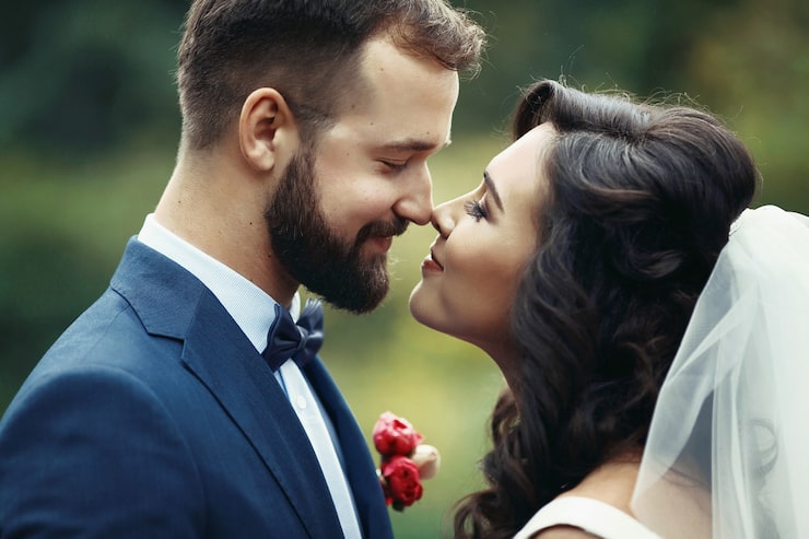 Foto gratuito una pareja feliz de recién casados mirándose el uno al otro en un parque.