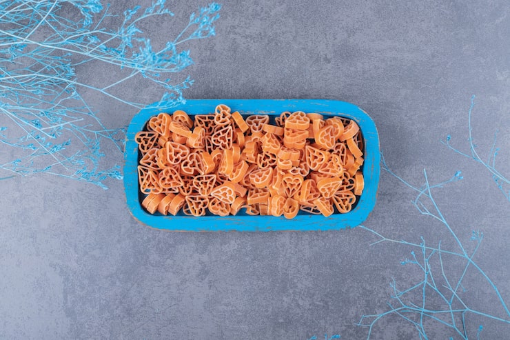 Photo Gratis pasta mentah berbentuk hati di atas piring biru.