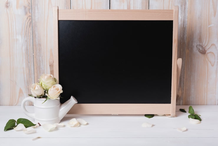 Foto gratuito pizarra en blanco con hermosas rosas en mesa de madera