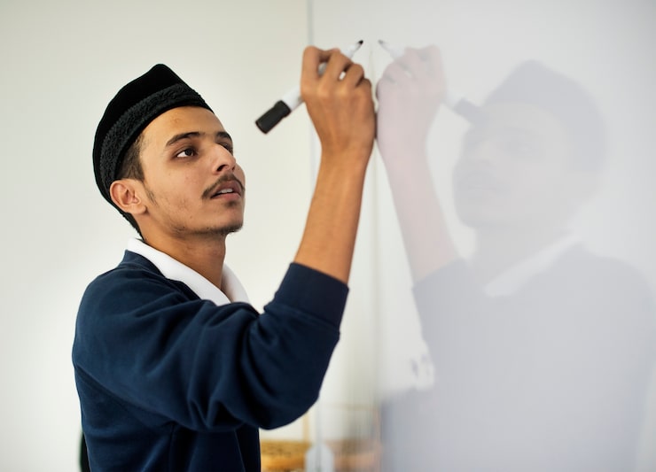Photo Gratis pria muslim muda sedang menulis di papan tulis