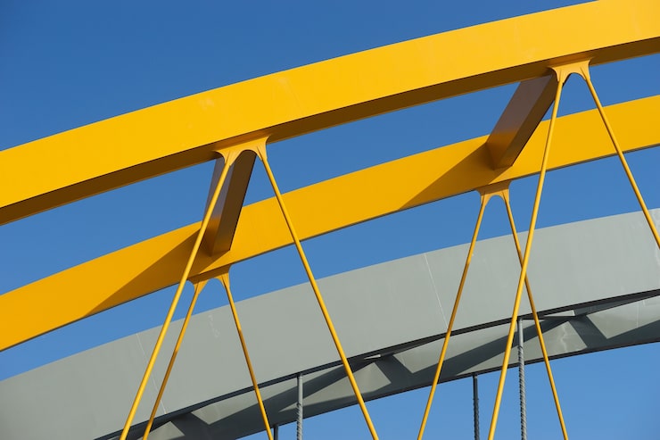 Foto gratuito primer plano de un arco de metal amarillo bajo un cielo azul