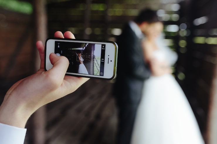 Foto gratuito primer plano de móvil haciendo una foto de los recién casados