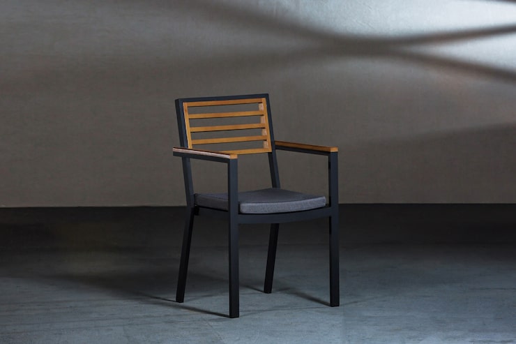 Foto gratuito un primer plano de una simple silla moderna con patas metálicas en una habitación con paredes grises