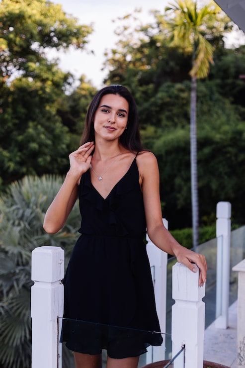 Foto gratuito retrato al aire libre de mujer en vestido negro con collar de plata nudo celta