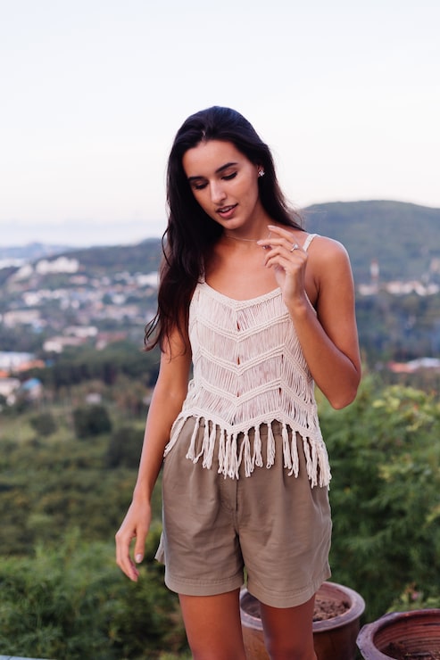 Foto gratuito retrato de feliz mujer romántica tranquila caucásica en look casual con el pelo largo con aretes y collar sobre fondo increíble vista hermosa en montañas verdes