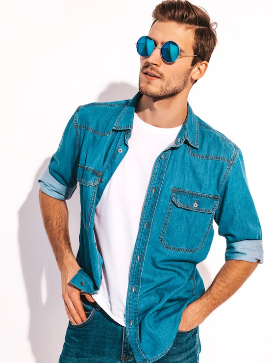 Foto gratuito retrato de guapo sonriente elegante joven modelo vestido con ropa de jeans. hombre de moda con gafas de sol.