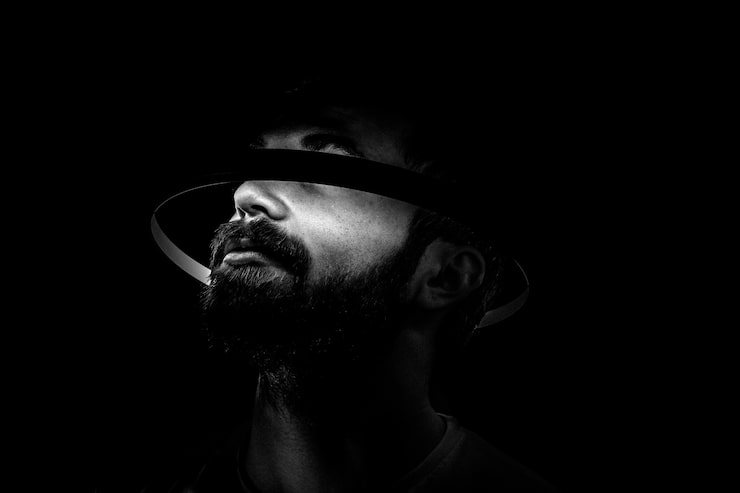 Foto gratuito retrato de un hombre barbudo con un círculo de luz alrededor de la cabeza