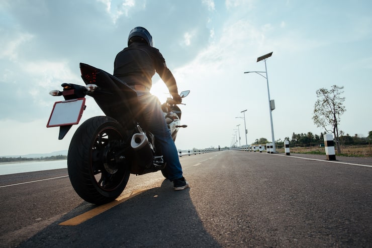 Foto gratuito rider moto en la carretera. divirtiéndose conduciendo el camino vacío