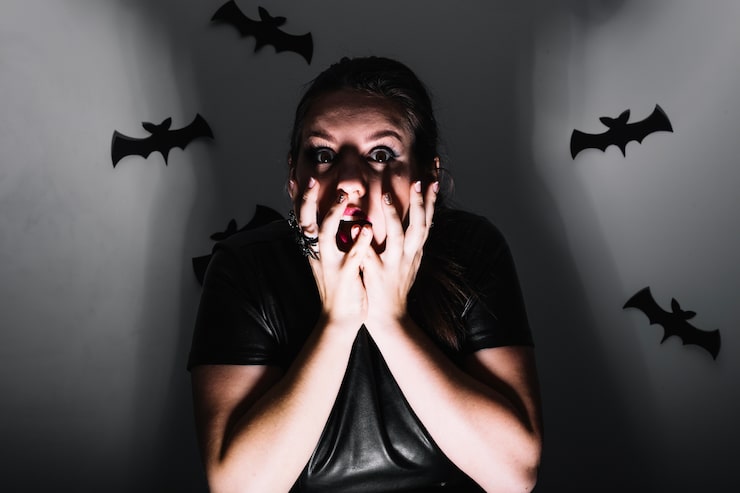 Foto gratuito scared chica en el estudio con los murciélagos