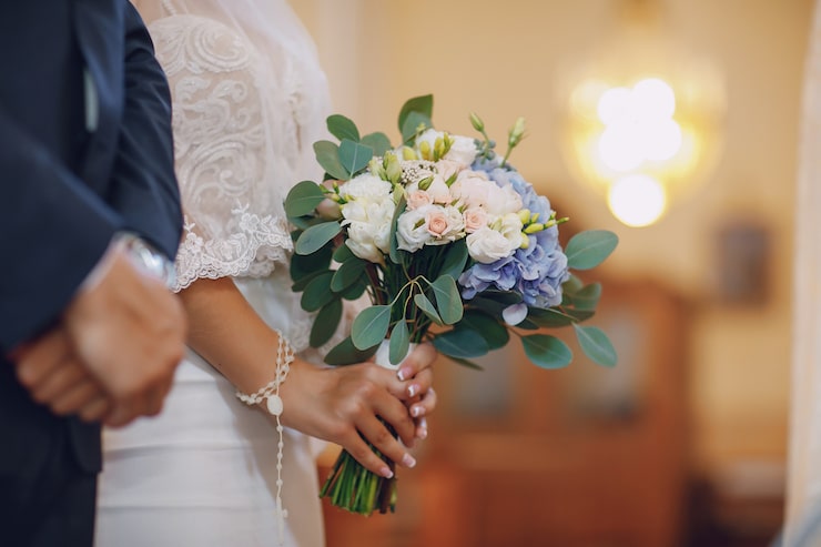 Photo Gratis seorang pengantin wanita muda dan cantik berdiri bersama suaminya di sebuah gereja