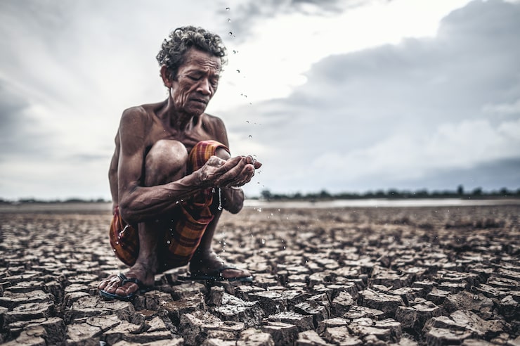 Photo Gratis seorang pria tua duduk bersentuhan dengan hujan di musim kemarau, pemanasan global, fokus seleksi