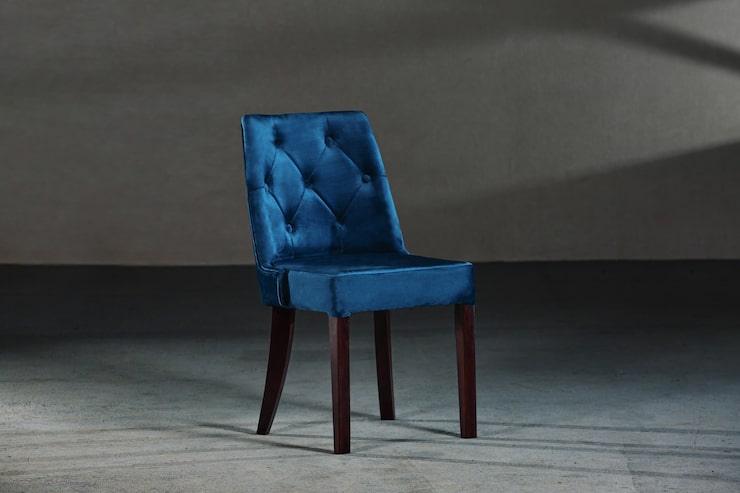 Foto gratuito silla de comedor azul en un estudio con paredes grises