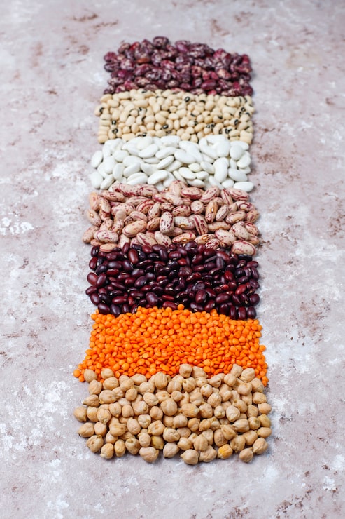 Foto gratuito surtido de legumbres y frijoles en diferentes cuencos sobre fondo de piedra clara. vista superior. alimentos proteicos veganos saludables.
