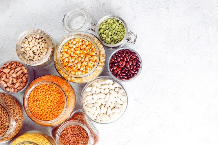 Foto gratuito surtido de legumbres y frijoles en diferentes cuencos sobre piedra clara. vista superior. alimentos proteicos veganos saludables.