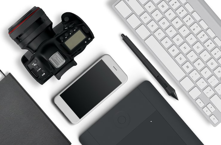 Photo Gratis tampilan atas desktop fotografer yang terdiri dari kamera, keyboard, ponsel pintar di latar belakang meja putih. masih hidup. tata letak datar