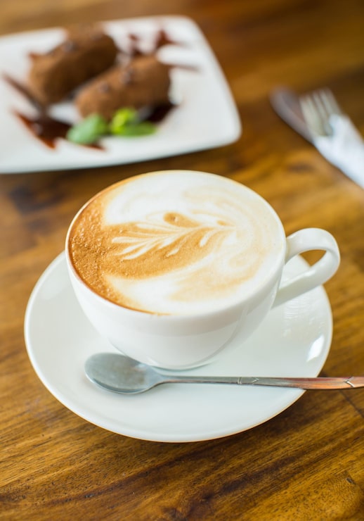 Foto gratuito tarta de chocolate kartoshka y capuchino en una mesa de madera