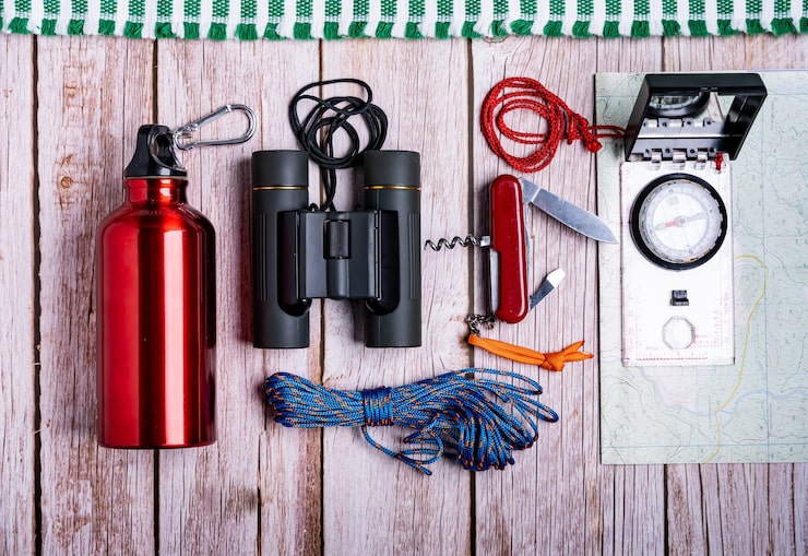 Photo Gratis tata letak peralatan hiking di permukaan kayu
