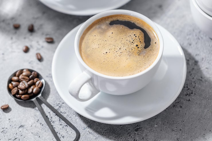 Foto gratuito taza de café en la mesa sobre fondo gris
