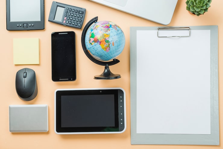 Photo Gratis teknologi di dekat clipboard dan bola dunia