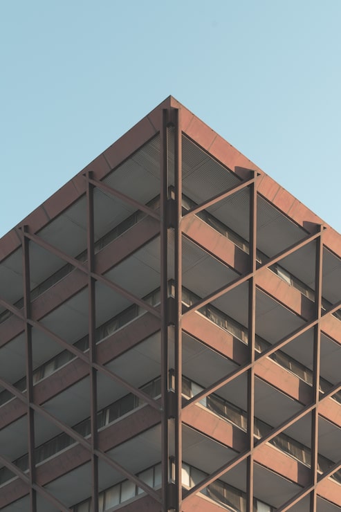Foto gratuito tiro de ángulo bajo de un edificio moderno en el centro de la ciudad bajo el cielo despejado