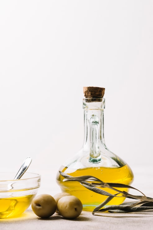 Foto gratuito tiro vertical botella de aceite de oliva con aceitunas