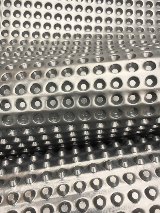 Foto gratuito tiro vertical de una superficie punteada de metal plateado