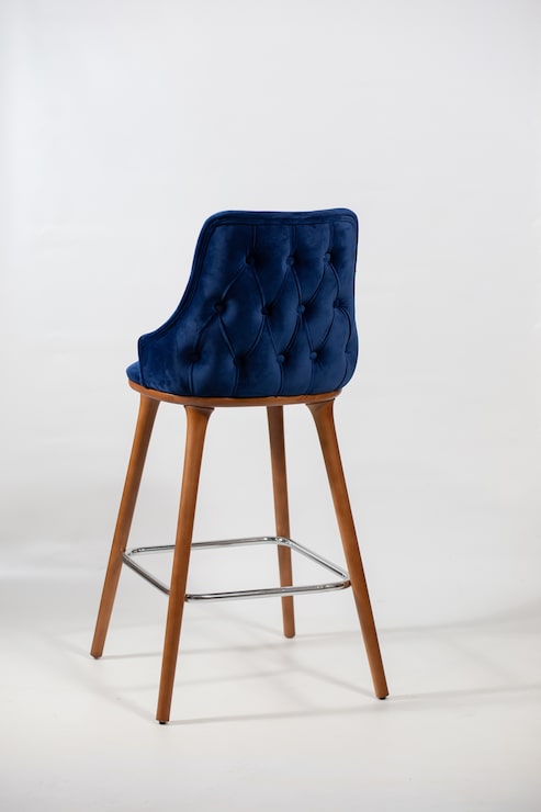 Foto gratuito tomada vertical de una silla azul hecha de patas de madera