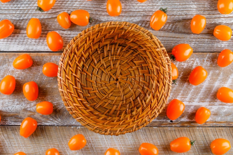 Foto gratuito tomates dispersos con la cesta vacía plana yacía sobre una mesa de madera