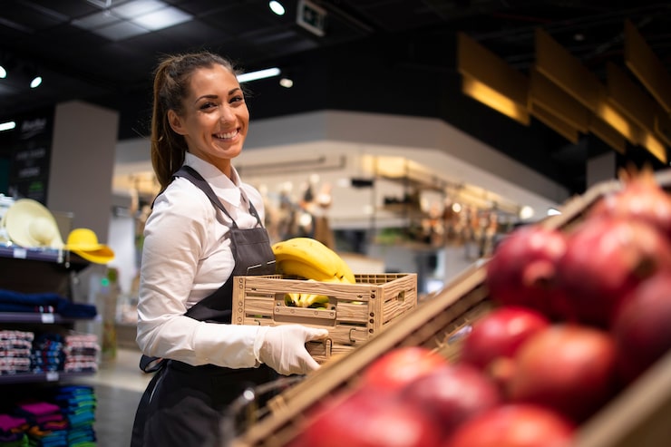 Foto gratuito trabajador de un supermercado que suministra alimentos al departamento de frutas