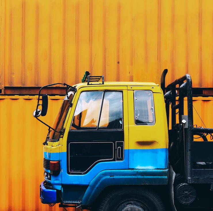Photo Gratis truk kuning diparkir di dekat kotak kontainer kuning