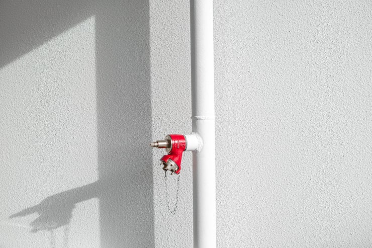Foto gratuito tubo blanco con extintor rojo