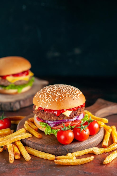 Foto gratuito vista frontal deliciosa carne hamburguesa con queso con papas fritas sobre fondo oscuro cena hamburguesa bocadillo comida rápida sándwich plato tostado
