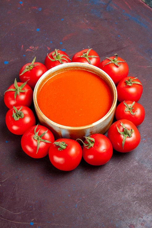 Foto gratuito vista frontal deliciosa sopa de tomate con tomates rojos frescos en el espacio oscuro