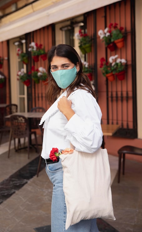 Foto gratuito vista lateral de la mujer con mascarilla y bolsas de la compra al aire libre