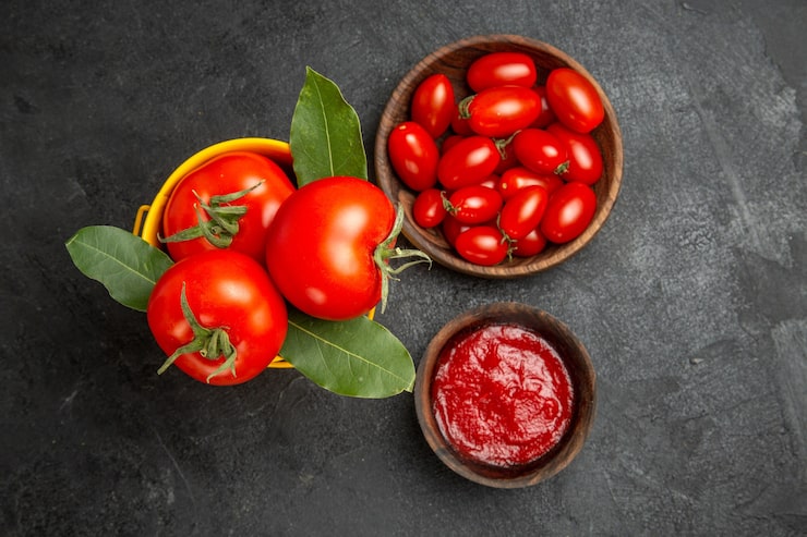Foto gratuito vista superior de un balde con tazones de tomates con tomates cherry y salsa de tomate en el espacio de tierra oscura py