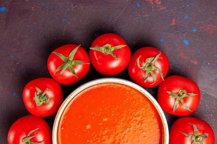 Foto gratuito vista superior cercana deliciosa sopa de tomate en un círculo con tomates rojos frescos en el espacio oscuro