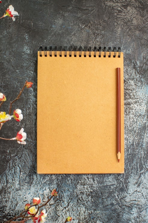 Foto gratuito vista superior del cuaderno marrón con bolígrafo