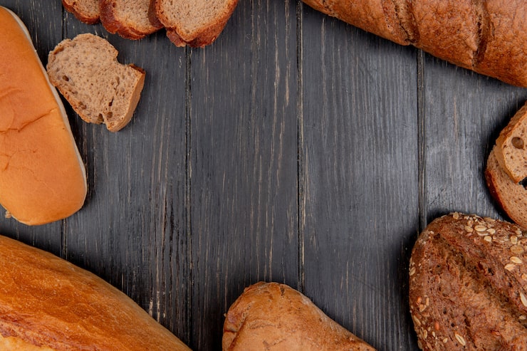 Foto gratuito vista superior de diferentes panes como sándwich de baguette de centeno negro sobre fondo de madera con espacio de copia