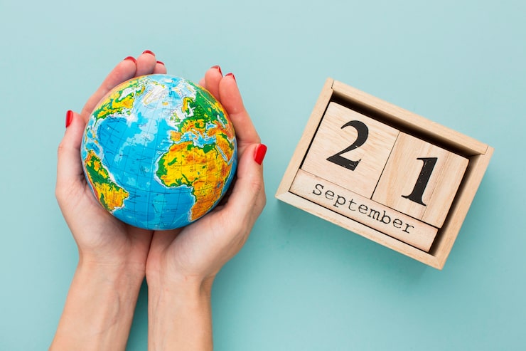 Foto gratuito vista superior de manos sosteniendo el planeta tierra con calendario