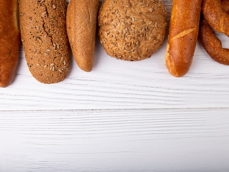 Foto gratuito vista superior de panes como baguette cob bagel sobre fondo de madera con espacio de copia