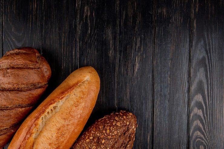 Foto gratuito vista superior de panes como vietnamita y baguette con semillas negras y pan negro sobre fondo de madera con espacio de copia