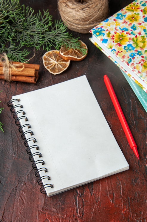 Foto gratuito vista vertical del cuaderno cerrado con lápiz canela limas una bola de cuerda y libros sobre fondo oscuro